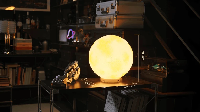 A printed moon lamp with the L4's build dimensions drawn around it: 354 mm wide, 370 mm deep, 386 mm tall (LightMake official media)